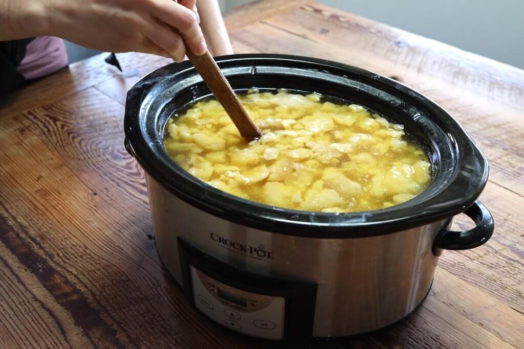 stirring rendered tallow in a crockpot